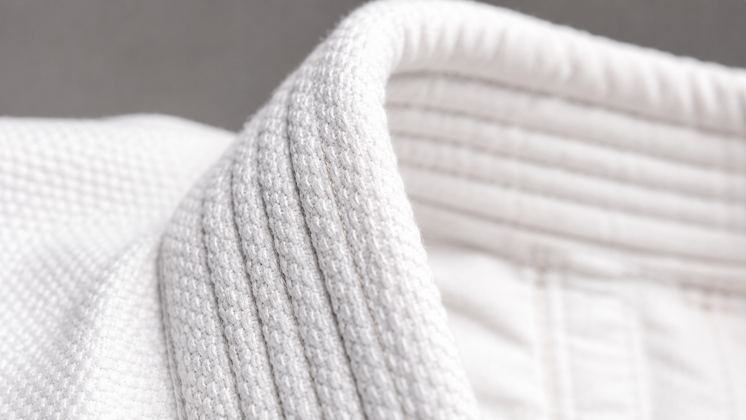 Close-up of a white BJJ gi collar showing pearl weave fabric construction detail