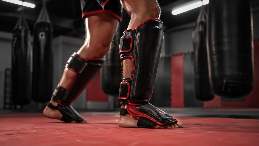 Muay Thai fighter wearing black and red shin guards during pad work — Australia