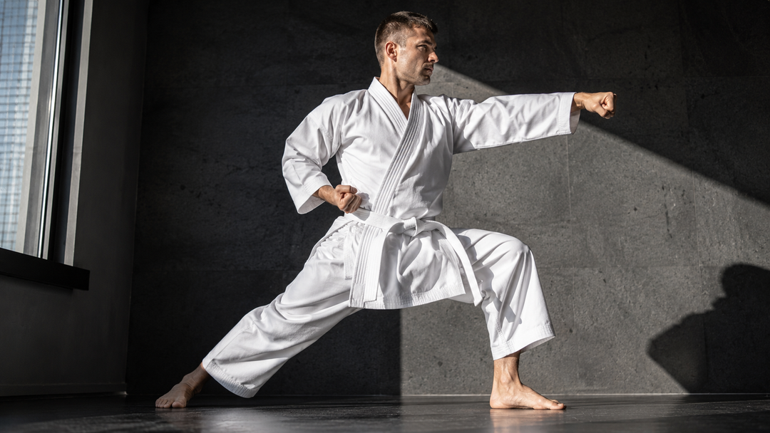 Karateka in white heavyweight karate gi executing a reverse punch kata stance